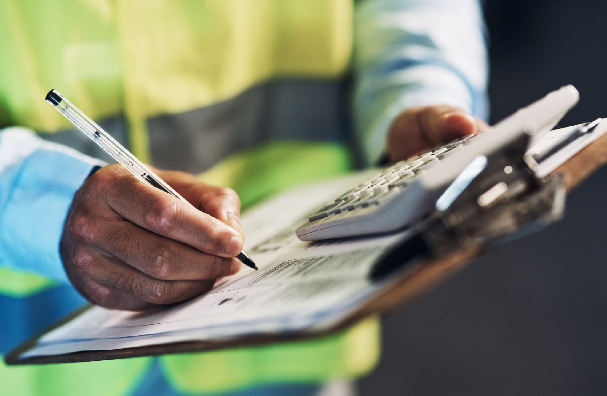 Our stock-take needs to be accurate. an unrecognizable contractor standing alone in the warehouse and writing on a document during stock-take